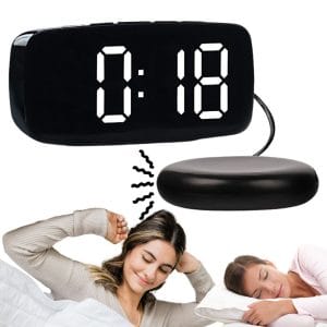 Črna LCD budilka z vibracijsko ploščo, idealna za vzglavnik, prikazuje čas.